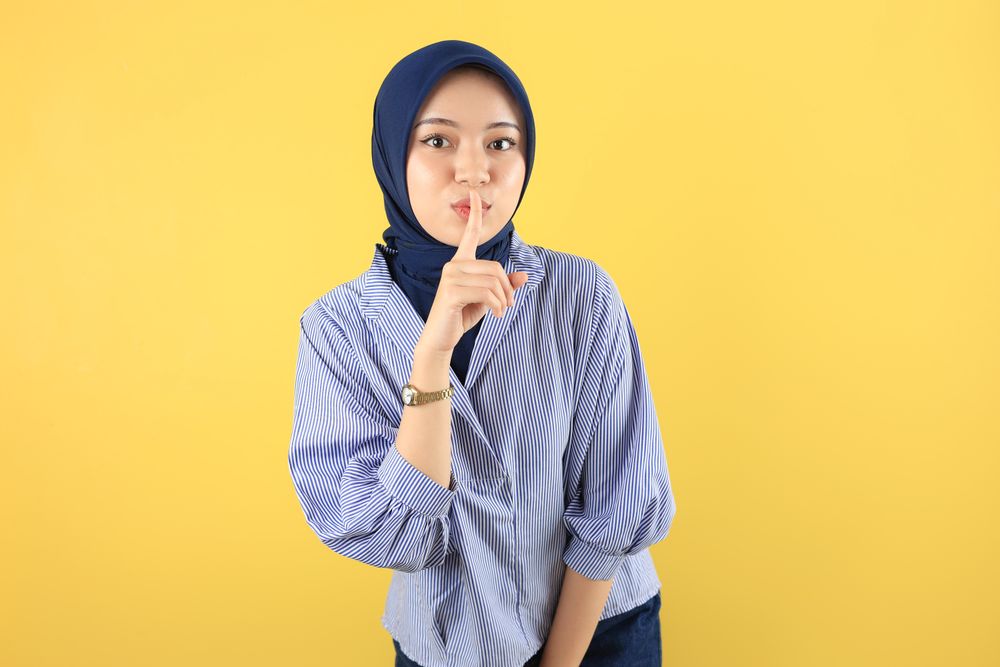 Serious Young Asian Muslim Woman Showing Silence Gesture