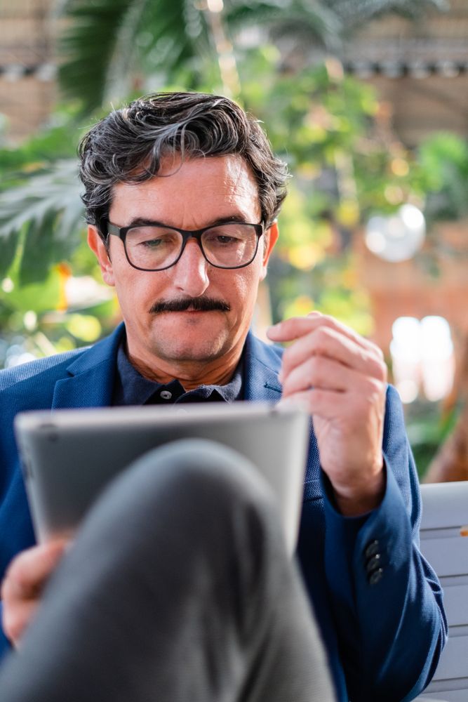 Older handsome man using digital tablet outdoors