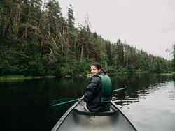 Woman boating on forest river in Finland