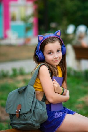 Preteen school girl with book on bench in park