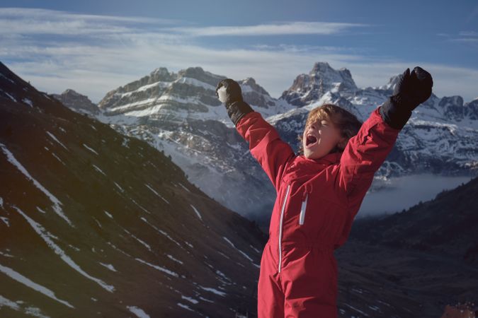 Child shouting against snowy mountain range