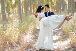 Husband carrying his new wife in forest