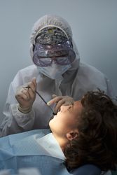 Unrecognizable dentist examining patient in hospital