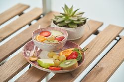 Delicious fruits with yogurt on table