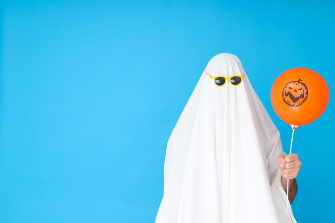 Concept of Halloween, Ghost in sunglasses on blue background