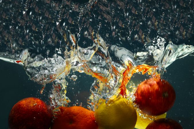 Side view of citrus fruits falling into water