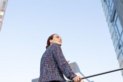 Serious businesswoman leaning on railing