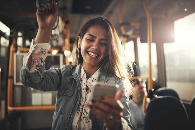 Woman smiling while video calling on phone on public transport