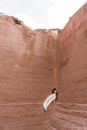 Elegant female posing on rocky cliff