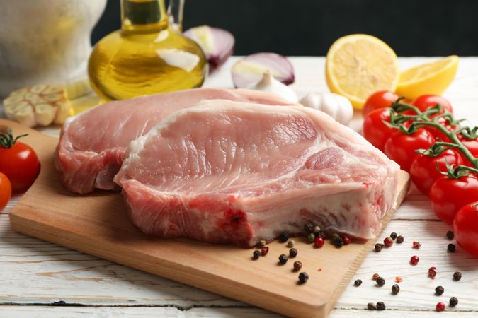 Composition with raw meat for steak and ingredients on wooden background