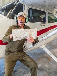 Pilot with map beside small plane