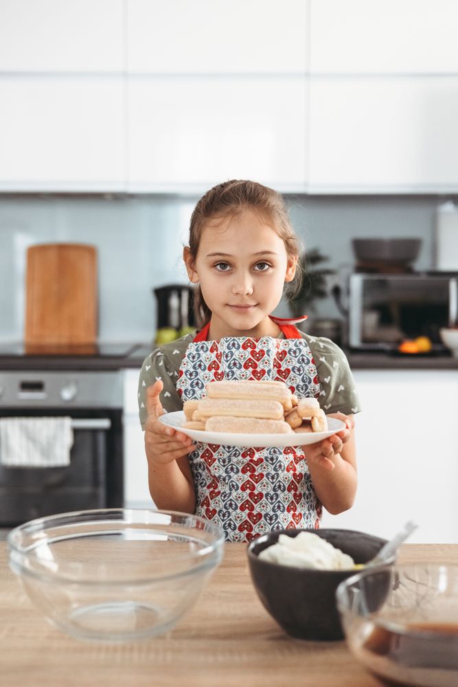 Girl with ingredients to make tiramisu dessert