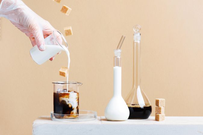 Laboratory for making coffee drinks with coffee and milk in beakers and sugar cubes