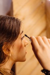 Young female applying mascara in front of mirror