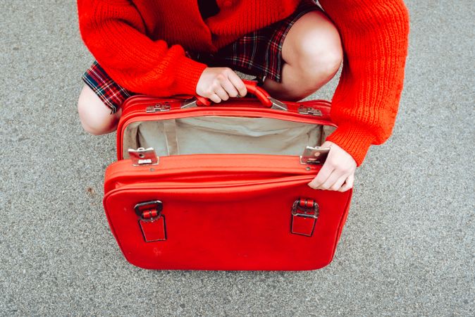 Woman opening suitcase on road