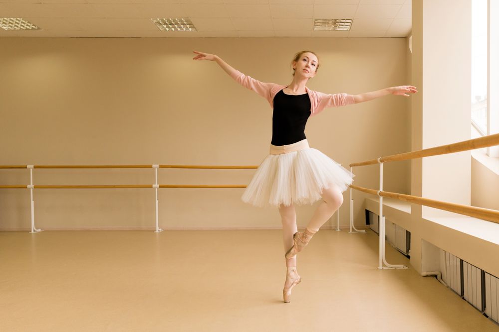Ballet dancer extends her arms in controlled position