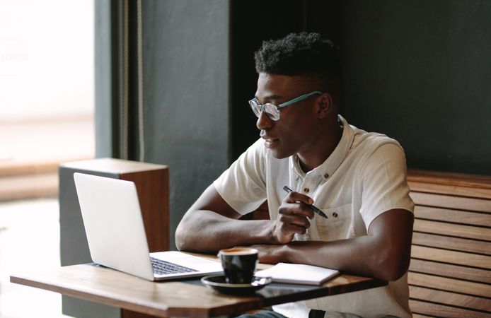 Black male working on computer at a coffee shop