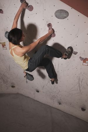 Young woman climbing on wall