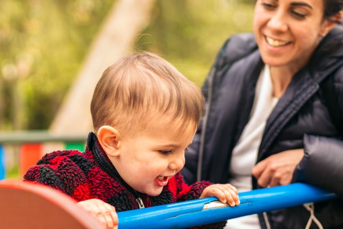 smiling mother and baby playing in a playground