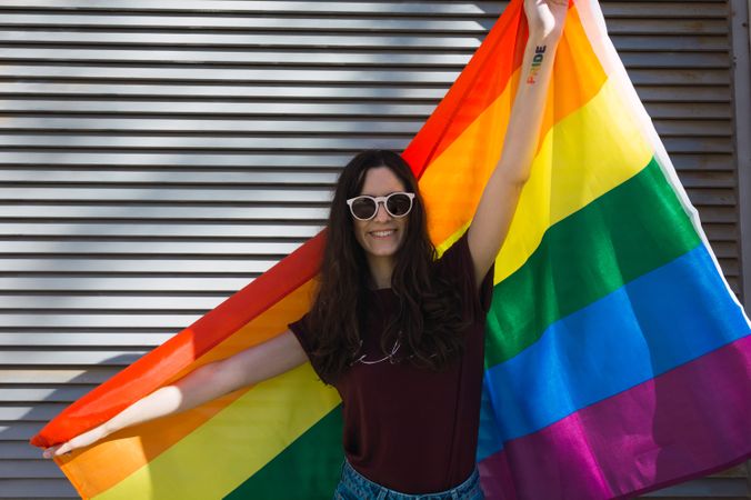 Woman posing happily with the rainbow flag