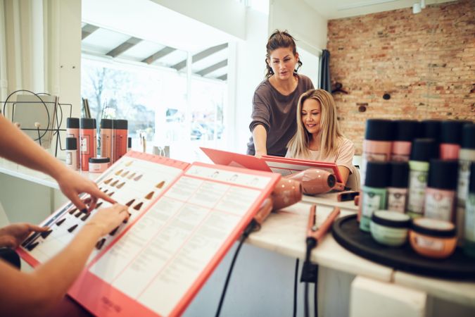 Hairdresser is helping customer select color from sample book