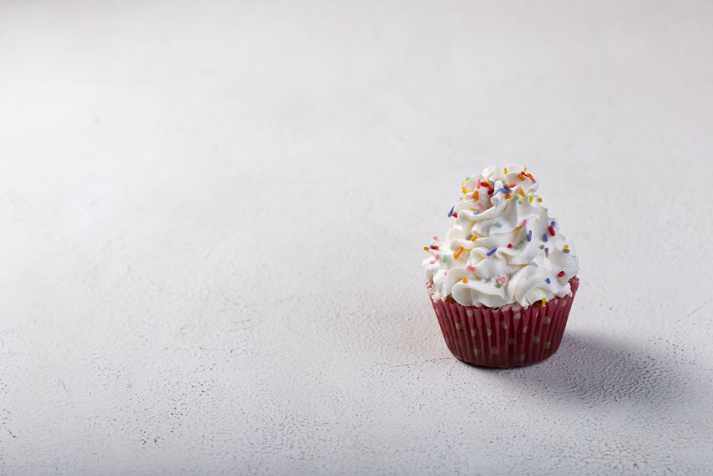 Tasty party cupcakes on the table. Cupcakes with whipped cream.