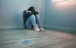 Unrecognizable woman covering her face desperate for cyberbullying