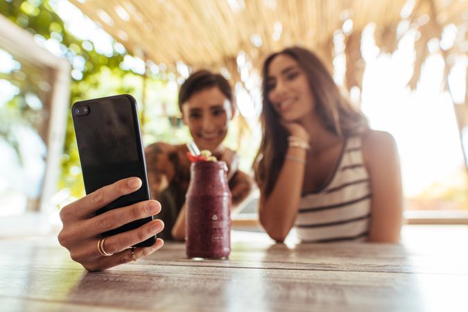 Woman shooting selfie with a friend at a restaurant