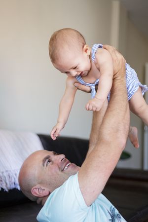 Happy father playing with baby