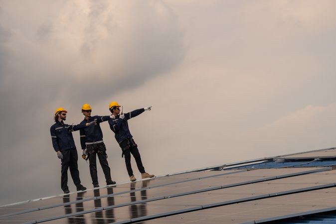 Engineer team checking solar cell  or photovoltaic cell installed on the roof of the factory. Technician worker repair or inspect the system. Industrial renewable energy concept