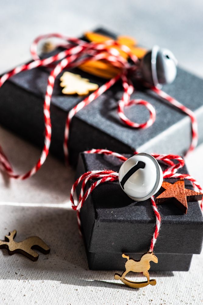 Close up of Christmas gift boxes with holiday decor on stone background with copy space