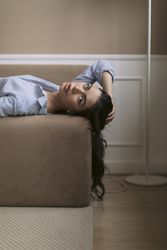 Woman lying on a couch with her hair draped over the side