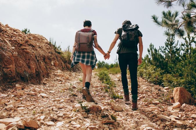 Couple wearing backpacks on a holiday hiking on a hill
