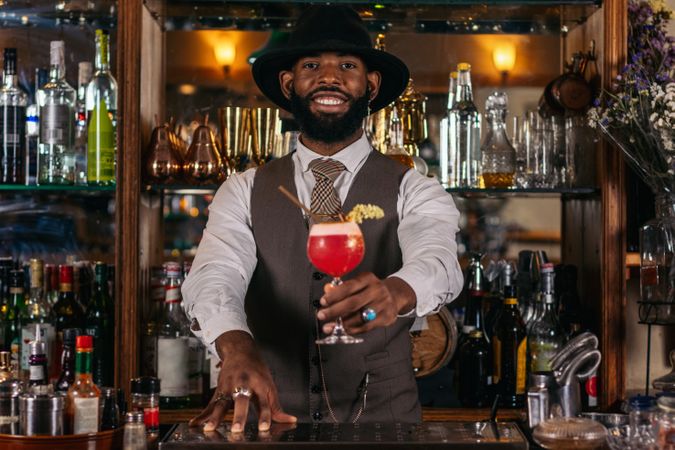 stylish Black bartender offering a customer a cocktail