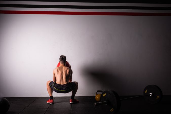 Man throwing ball on wall in gym
