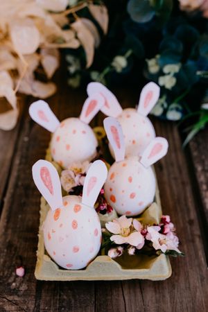 Easter eggs with rabbit ears in container