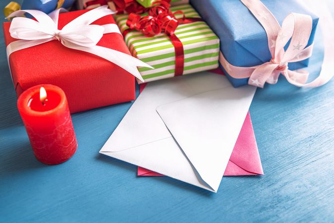 Colorful gifts and blank envelops on blue table