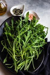 Healthy food concept with dark plate full of arugula