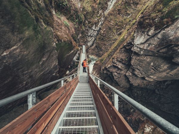Tourist on hiking path among rocky slopes