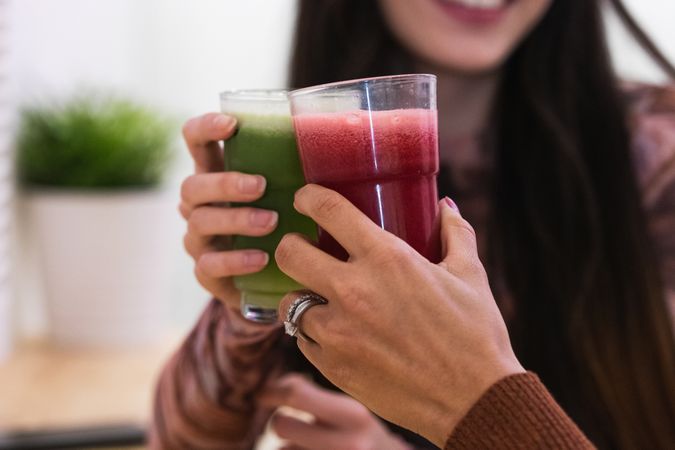 Anonymous diverse women drinking smoothie in bar