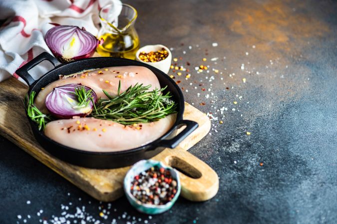 Raw chicken in pan ready to cook on cutting board with copy space