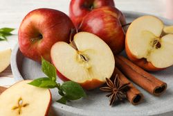 Apples and cinnamon sticks on plate for autumn baking