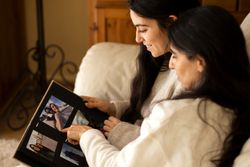 Family watching a photo album of themselves.