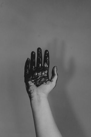 Grayscale photo of hand with dark paint