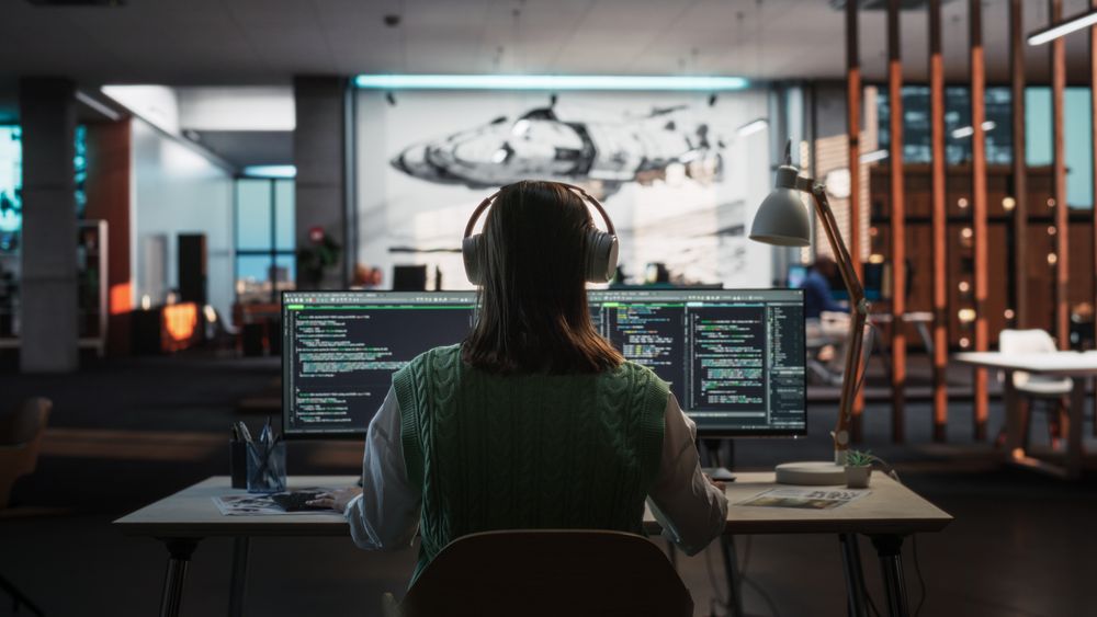 Creative Office: Professional Female Programmer Uses Headphones, Working on Desktop Computer.