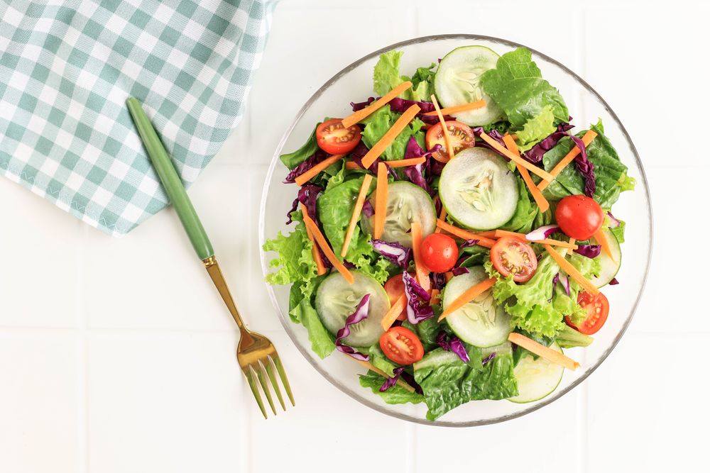 Healthy vegetable Salad with Purple Cabbage, Cherry Tomato, Sliced Cucumber, Carrot, and Lettuce