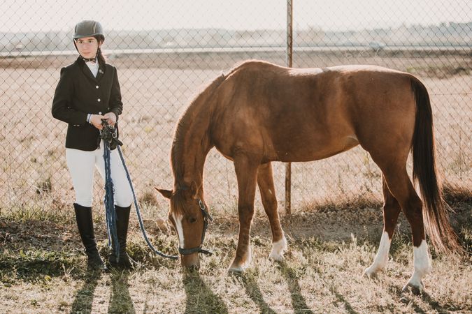 Teen girl with horse on ranch