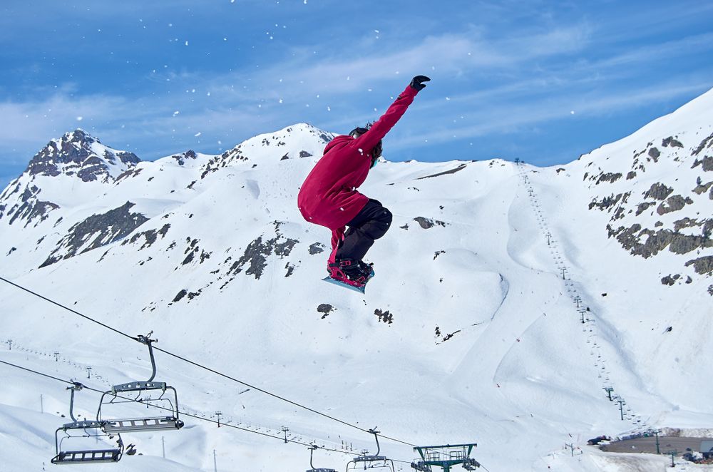 Unrecognizable snowboarder jumping on slope