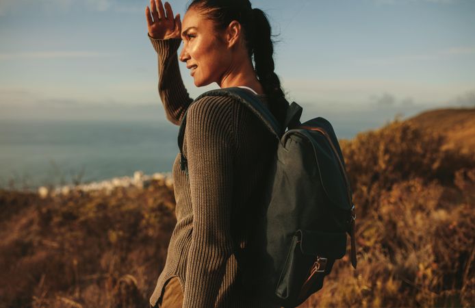 Woman hiker looking into the distance with hand over eyes