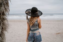 Young female relaxing on beach with hat